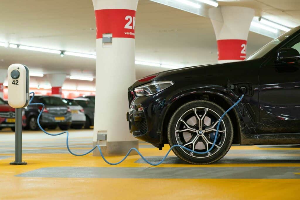 Une voiture électrique branchée sur une borne de recharge dont la puissance est adaptée.
